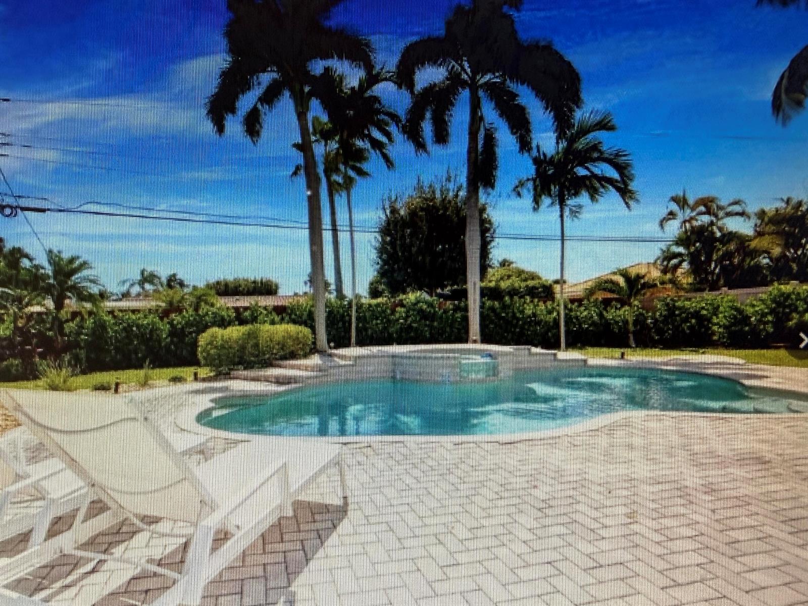 A backyard swimming pool with a brick paver patio and several tall palm trees — 70 SE 10th Street, Pompano Beach FL 33060, POMPANO BEACH, FL