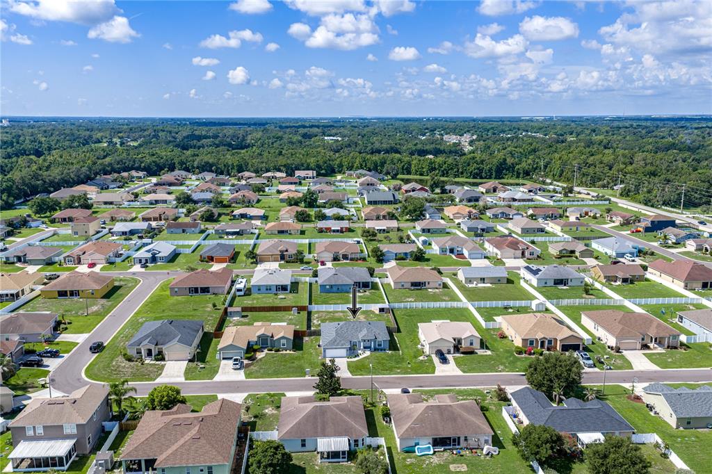 An aerial view shows a suburban neighborhood with a single-story house marked by an arrow — 2734 STONEWOOD DRIVE, LAKELAND, FL