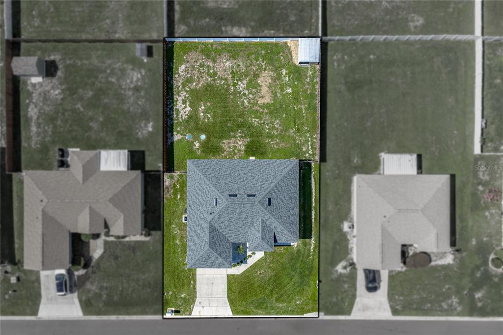 An aerial view shows a single-family home with a large backyard on a rectangular lot — 2734 STONEWOOD DRIVE, LAKELAND, FL