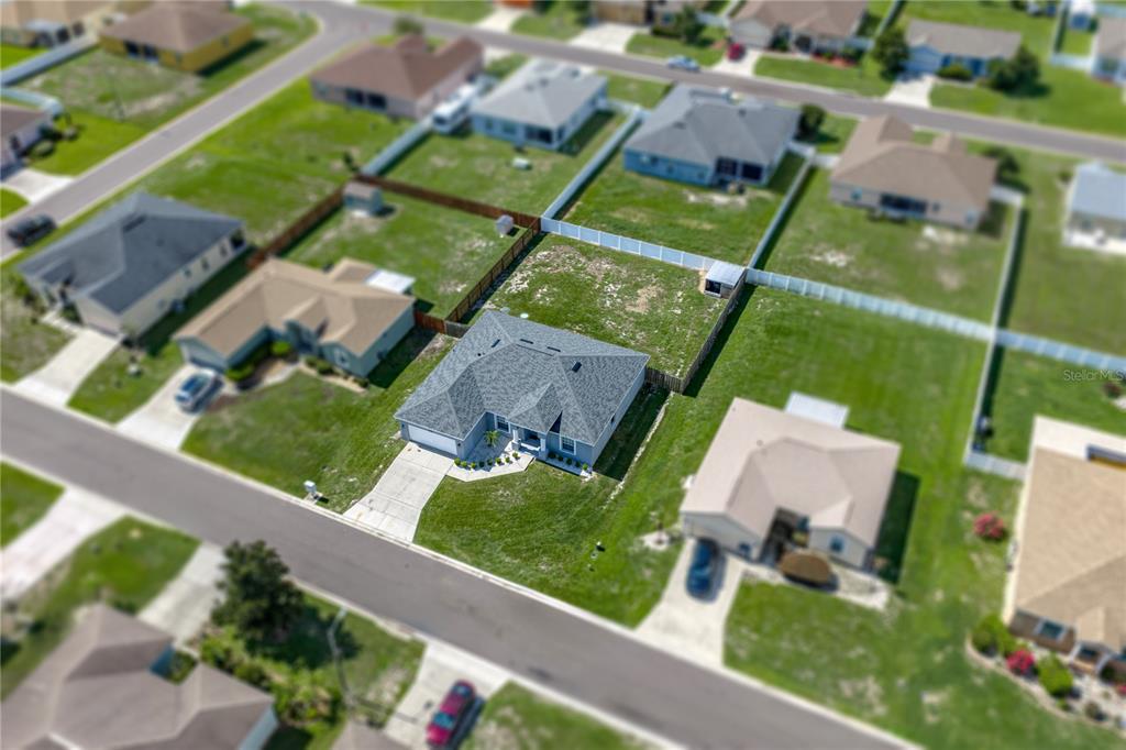 An aerial view shows a single-story house with a gray roof and a fenced backyard — 2734 STONEWOOD DRIVE, LAKELAND, FL