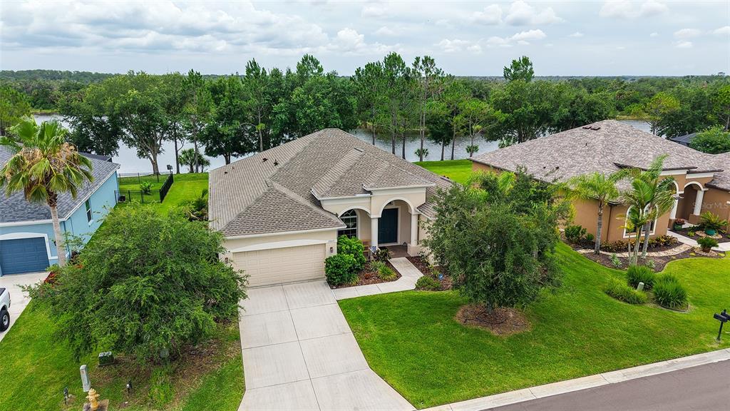 An aerial view shows a single-story house with a gray roof and a concrete driveway — 13515 22ND COURT E, PARRISH, FL