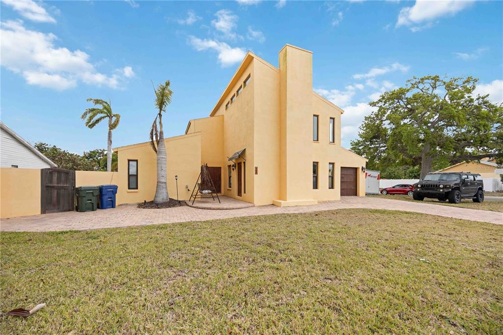 A yellow stucco house with a paved driveway, a palm tree, and a parked SUV — 6515 MAUNA LOA BOULEVARD, SARASOTA, FL