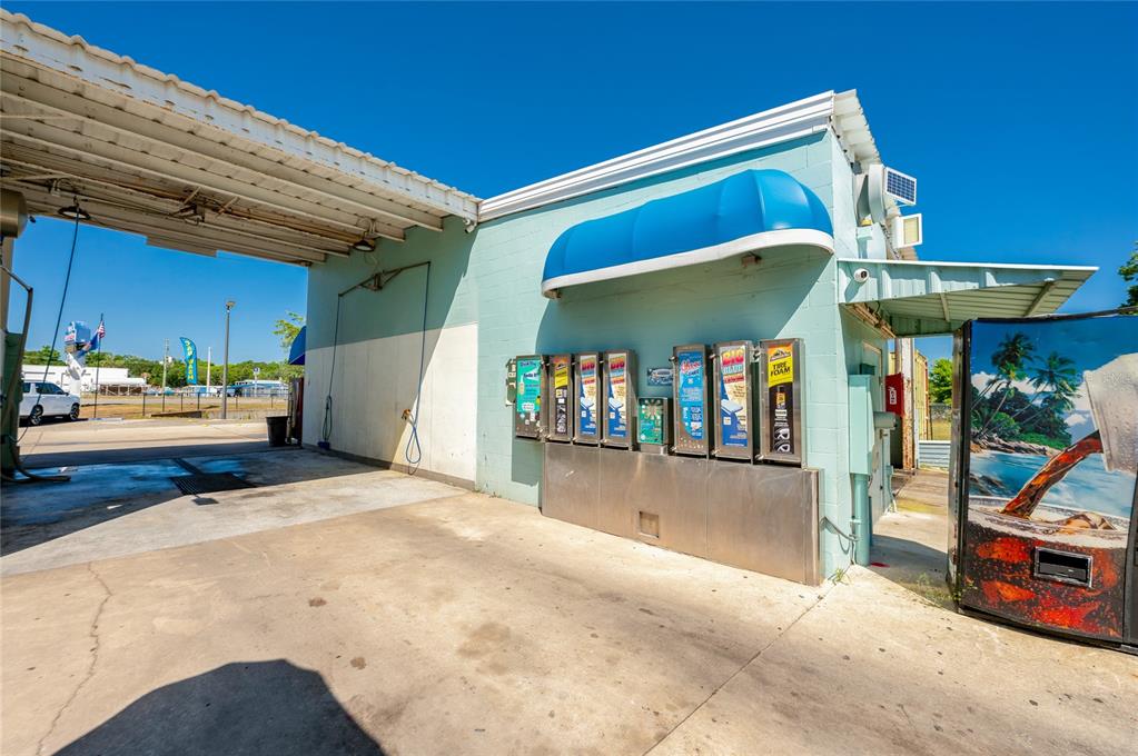 An outdoor car wash bay features a row of vending machines and a blue awning — 1451 N NOVA ROAD, DAYTONA BEACH, FL