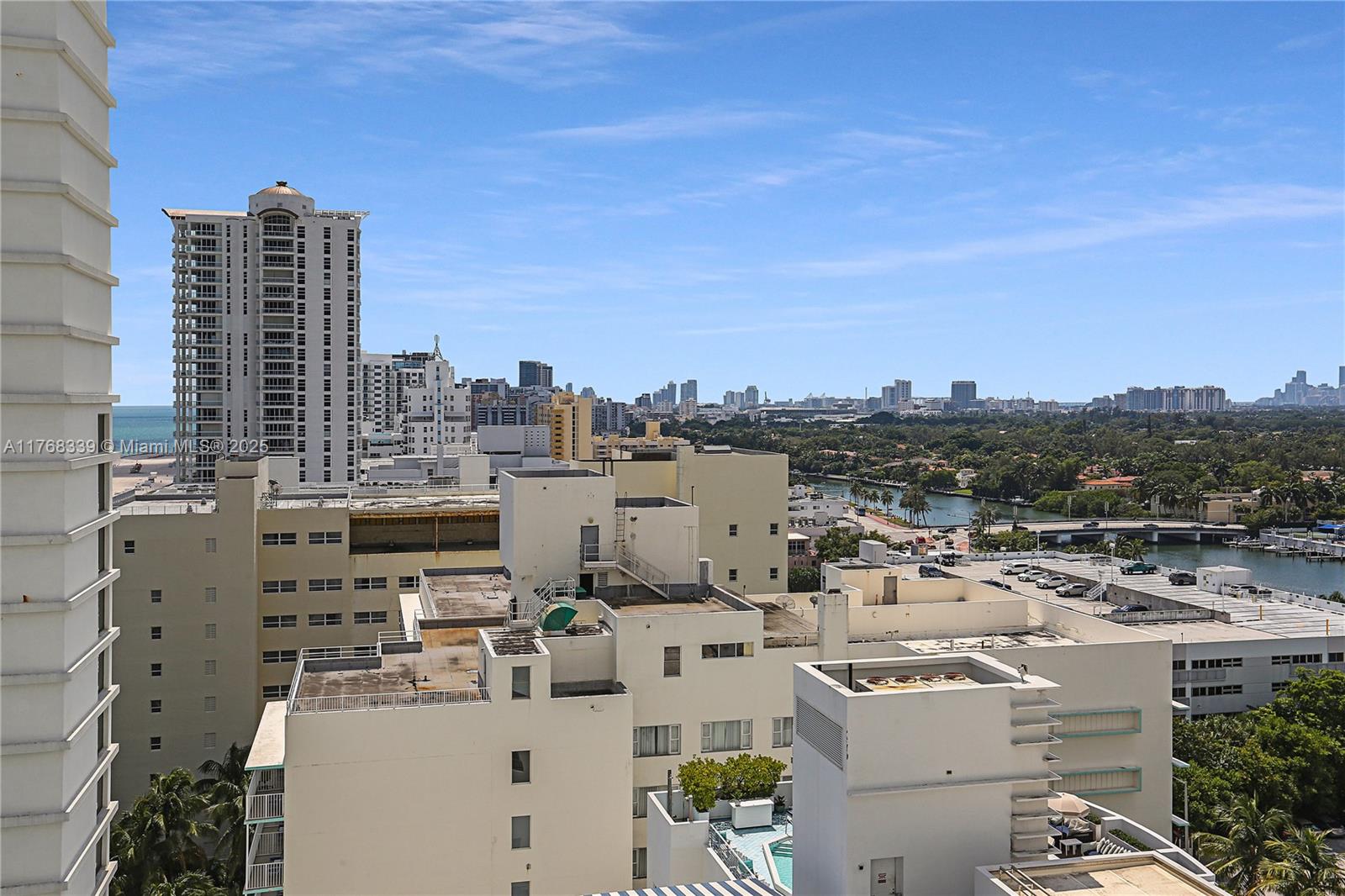 An elevated view shows a dense urban landscape with high-rise buildings, rooftops, and a waterway — 4391 Collins Ave # 1415, Miami Beach FL 33140, MIAMI BEACH, FL