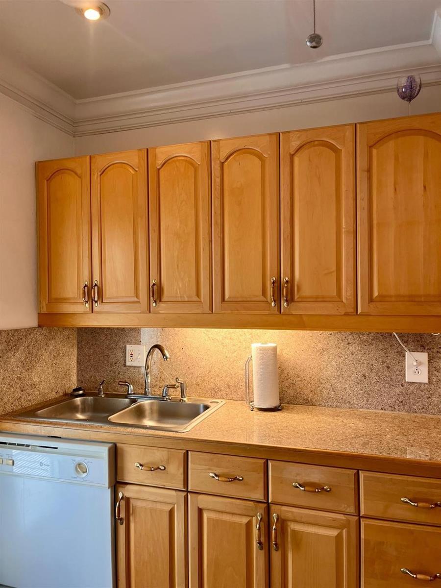A kitchen features light wood cabinets, a double-basin stainless steel sink, and speckled granite countertops — 1951 NE 39th Street # 361, Lighthouse Point FL 33064, LIGHTHOUSE POINT, FL