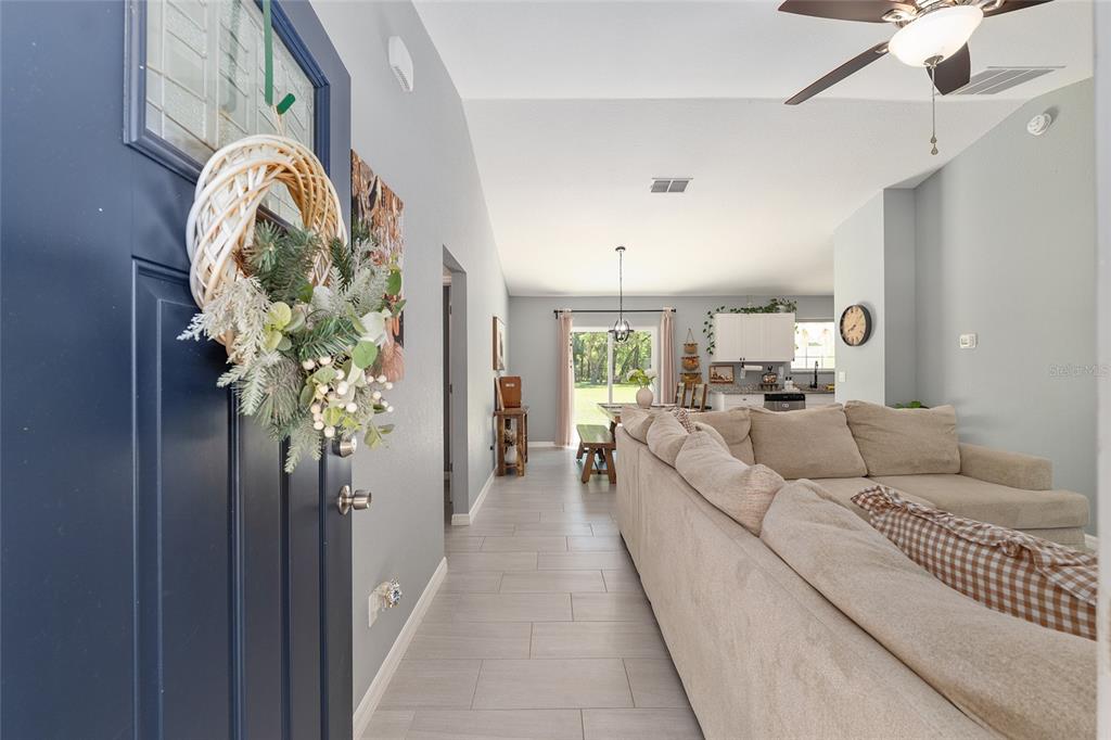 A view from an entryway into a living room with tile floors and a sofa — 20264 SW 69TH PLACE, DUNNELLON, FL