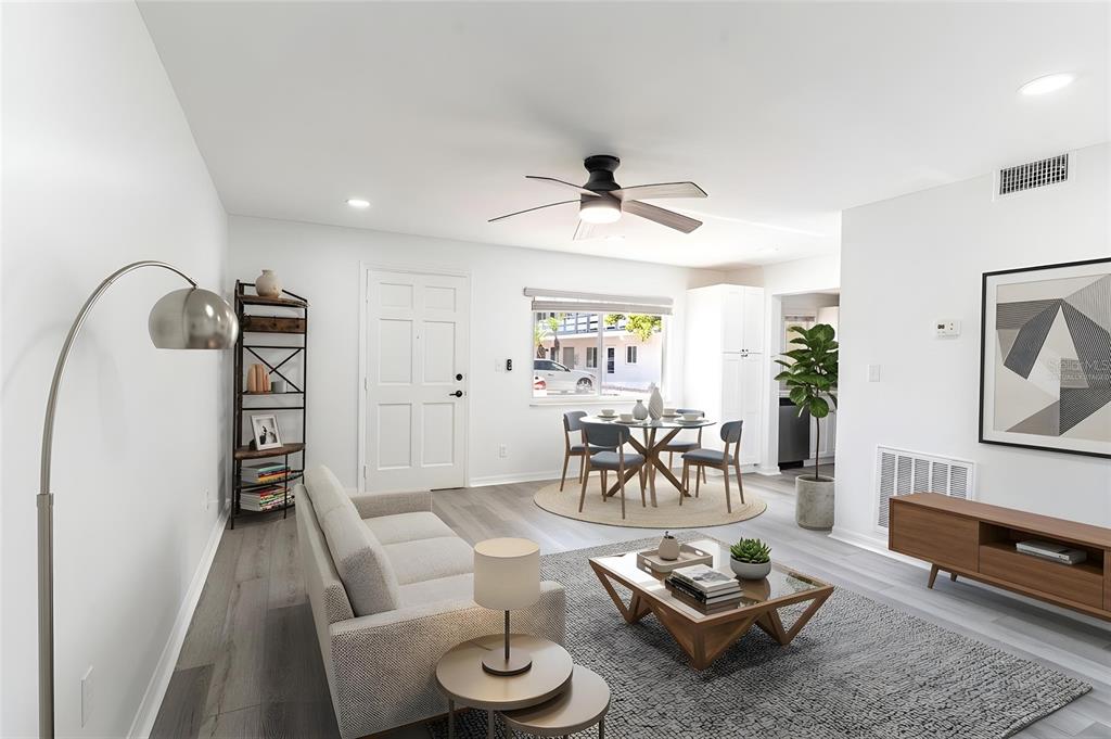 A living and dining area features light wood flooring, a ceiling fan, and modern furniture — 1100 MARTINIQUE DRIVE UNIT 106, WINTER HAVEN, FL