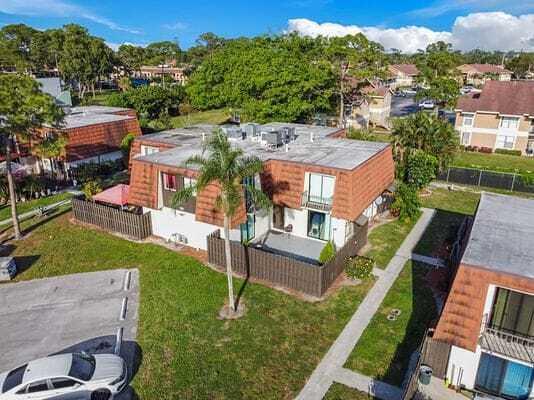 An aerial view of a multi-unit residential building with a brown mansard roof — 2168 White Pine Circle # D, FL 33415, FL