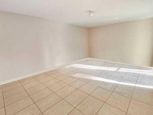 An empty room with beige walls and light-colored square floor tiles — 2168 White Pine Circle # D, FL 33415, FL