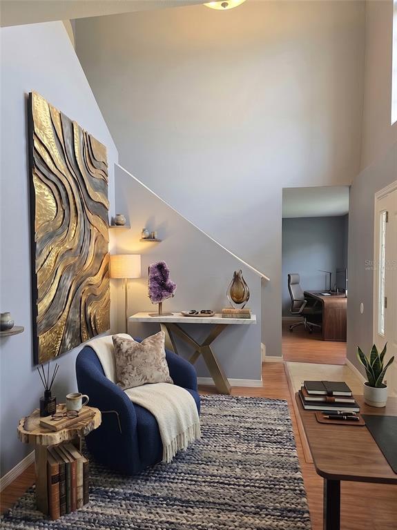 A blue armchair sits on a textured rug in a living area with wall art — 321 LAKE HILLS LANE, EAGLE LAKE, FL