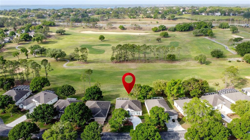 An aerial view shows a suburban house with a red location pin on a golf course — 3828 AVON COURT, CLERMONT, FL