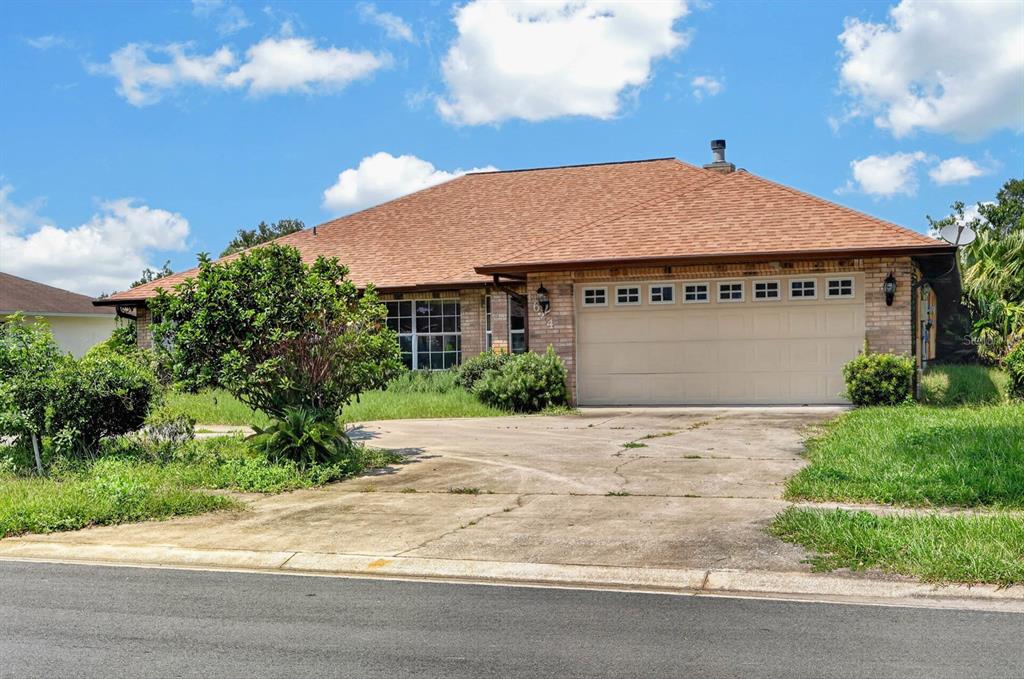 A single-story brick house with a two-car garage and a large, cracked concrete driveway — 1624 PICCADILLY DRIVE, DAYTONA BEACH, FL