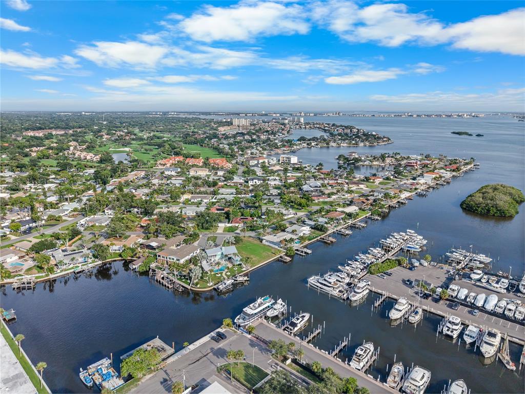 An aerial view shows a residential neighborhood with a marina, canal, and coastal landscape — 1301 SEA GULL DRIVE S, ST PETERSBURG, FL
