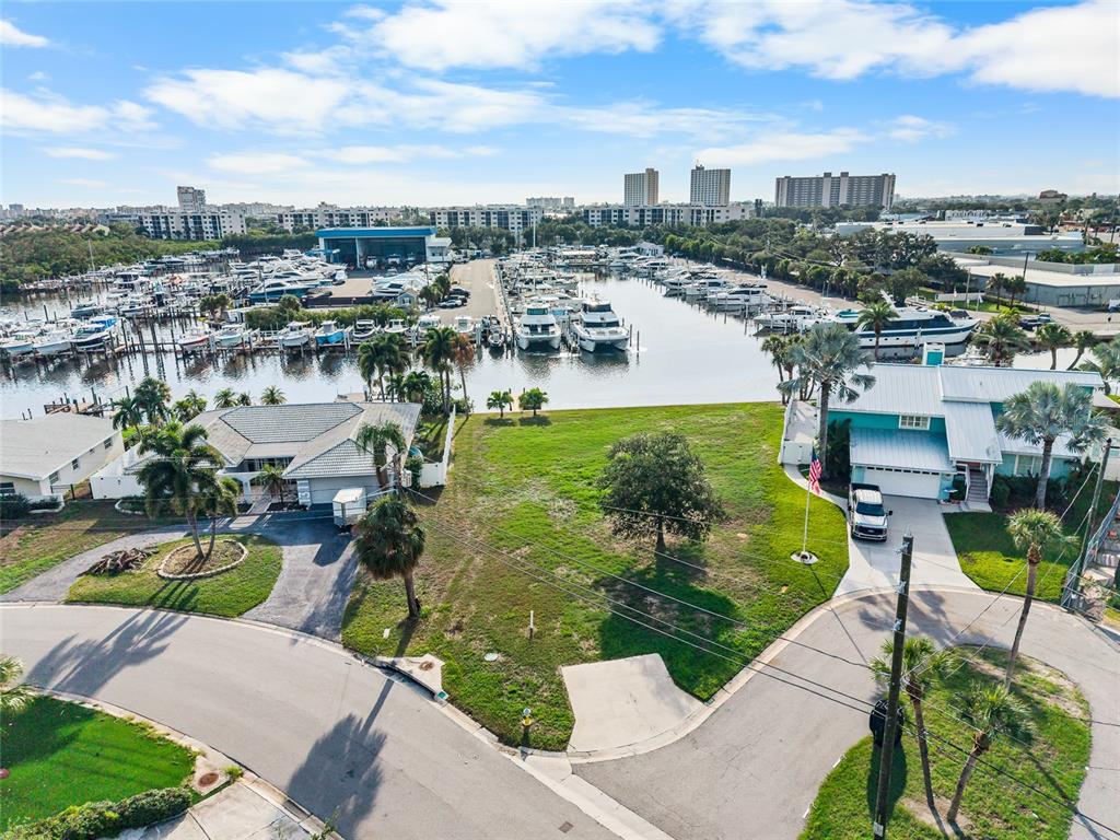 An aerial view shows a vacant grassy lot situated between two houses near a marina — 1301 SEA GULL DRIVE S, ST PETERSBURG, FL
