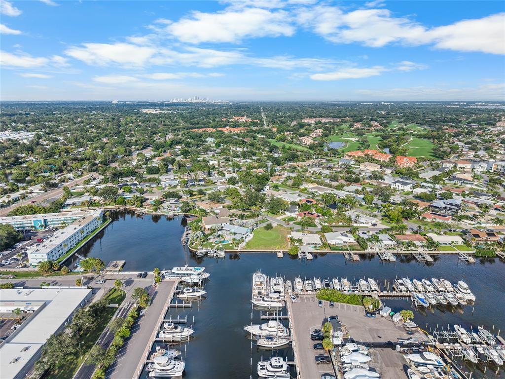 An aerial view shows a marina with numerous docked boats alongside residential neighborhoods and greenery — 1301 SEA GULL DRIVE S, ST PETERSBURG, FL