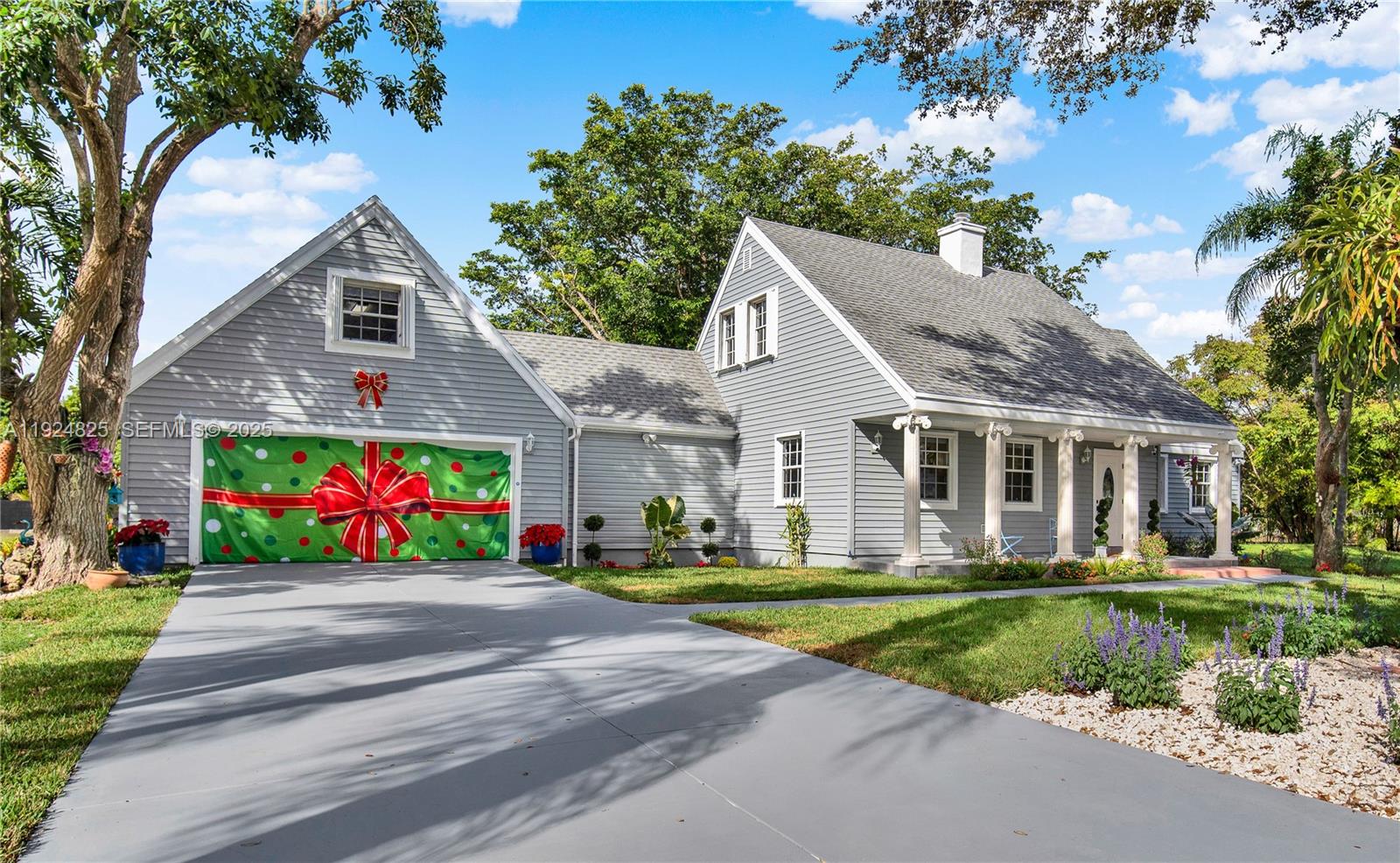 A gray two-story house features a garage door decorated with a large red gift bow — 22820 SW 179th Pl, Miami FL 33170, MIAMI, FL