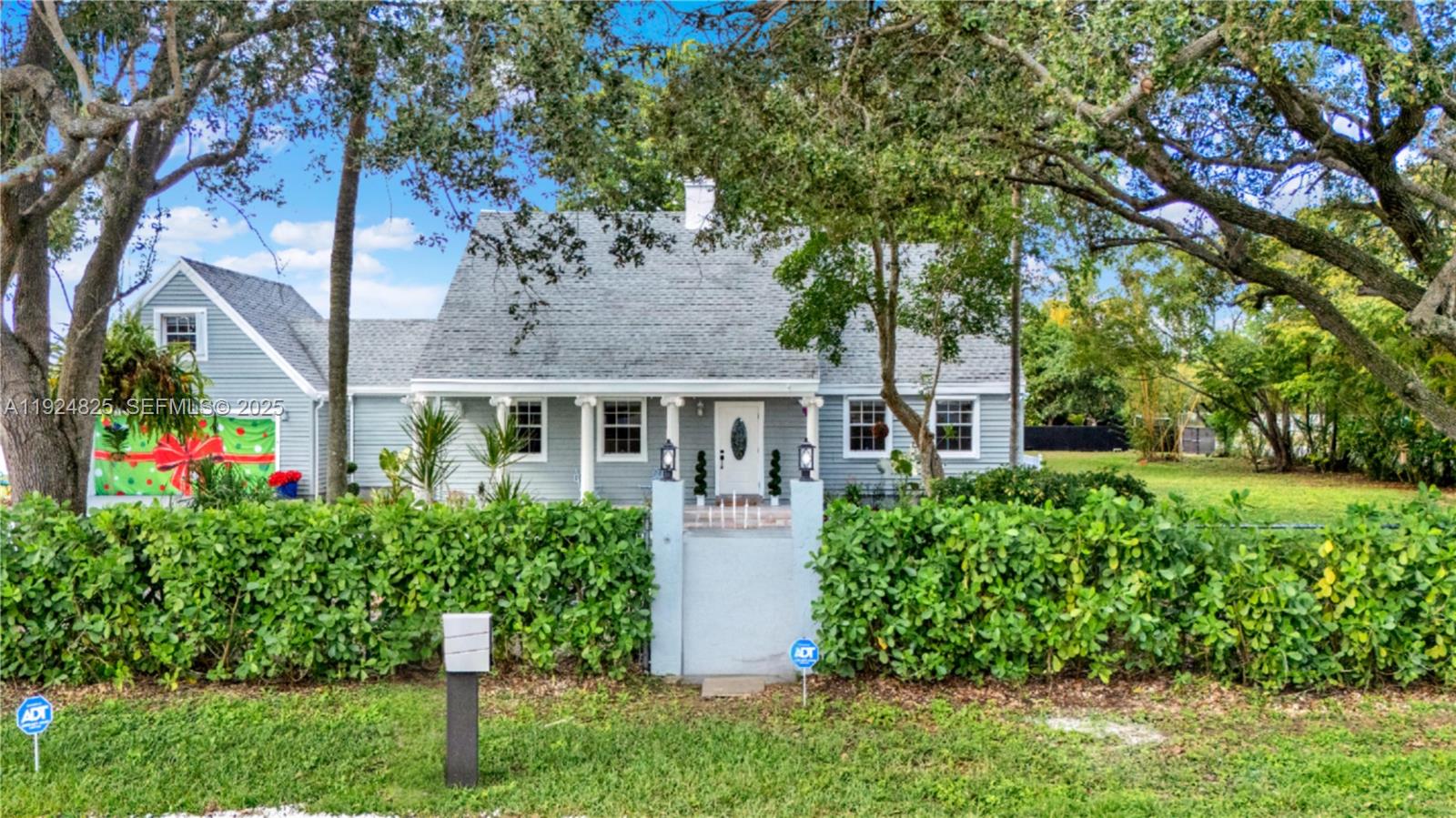 A light blue house with a gray roof sits behind a tall green hedge — 22820 SW 179th Pl, Miami FL 33170, MIAMI, FL