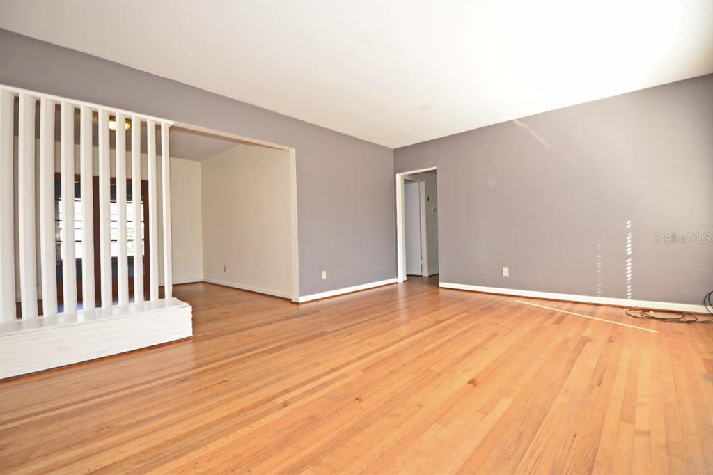 An empty room with hardwood floors, gray walls, and a white wooden room divider — 1337 CUMBIE STREET, ORLANDO, FL