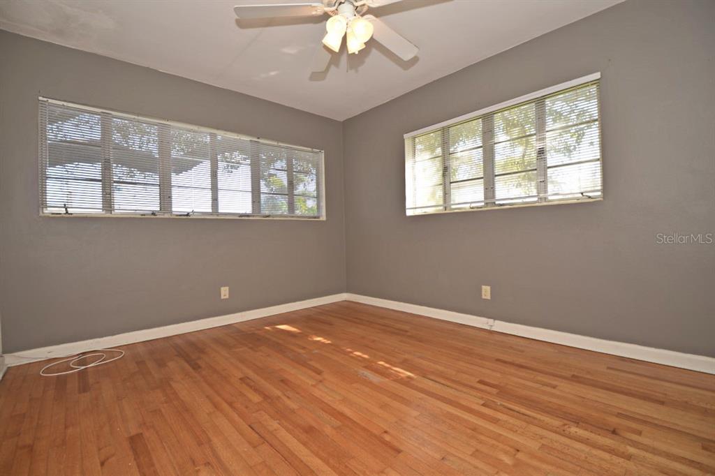 An empty bedroom features gray walls, hardwood floors, a ceiling fan, and two windows — 1337 CUMBIE STREET, ORLANDO, FL