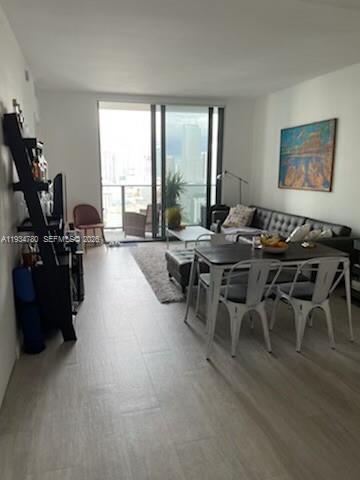 A living room features light tile floors, a dining set, a sofa, and a balcony view — 45 SW 9th St # 3210, Miami FL 33130, MIAMI, FL