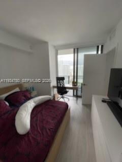 A bedroom features a bed with a burgundy comforter, a desk, and a balcony door — 45 SW 9th St # 3210, Miami FL 33130, MIAMI, FL