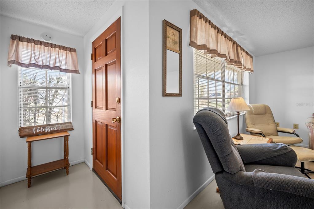 A living room features a wooden front door, a small side table, and two armchairs — 901 PONDEROSA ROAD, VENICE, FL