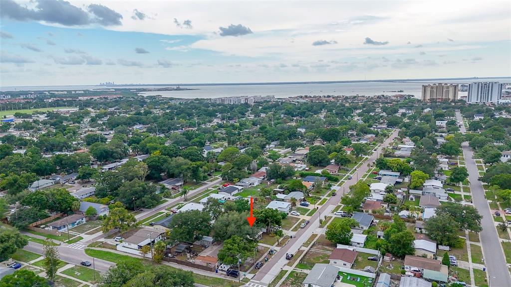 An aerial view shows a residential neighborhood with a red arrow pointing to a house — 4402 W TRILBY AVENUE, TAMPA, FL