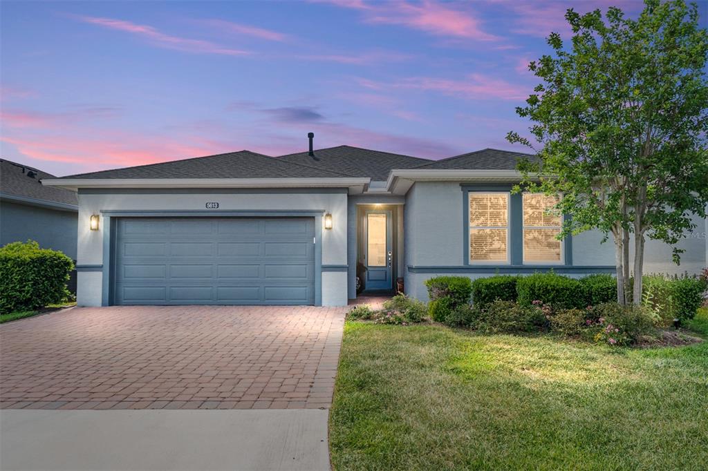 A single-story house with a two-car garage, paved driveway, and a landscaped front yard — 5613 NW 40TH LOOP, OCALA, FL