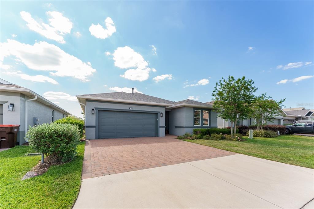 A single-story house with a gray exterior, a two-car garage, and a brick-paved driveway — 5613 NW 40TH LOOP, OCALA, FL