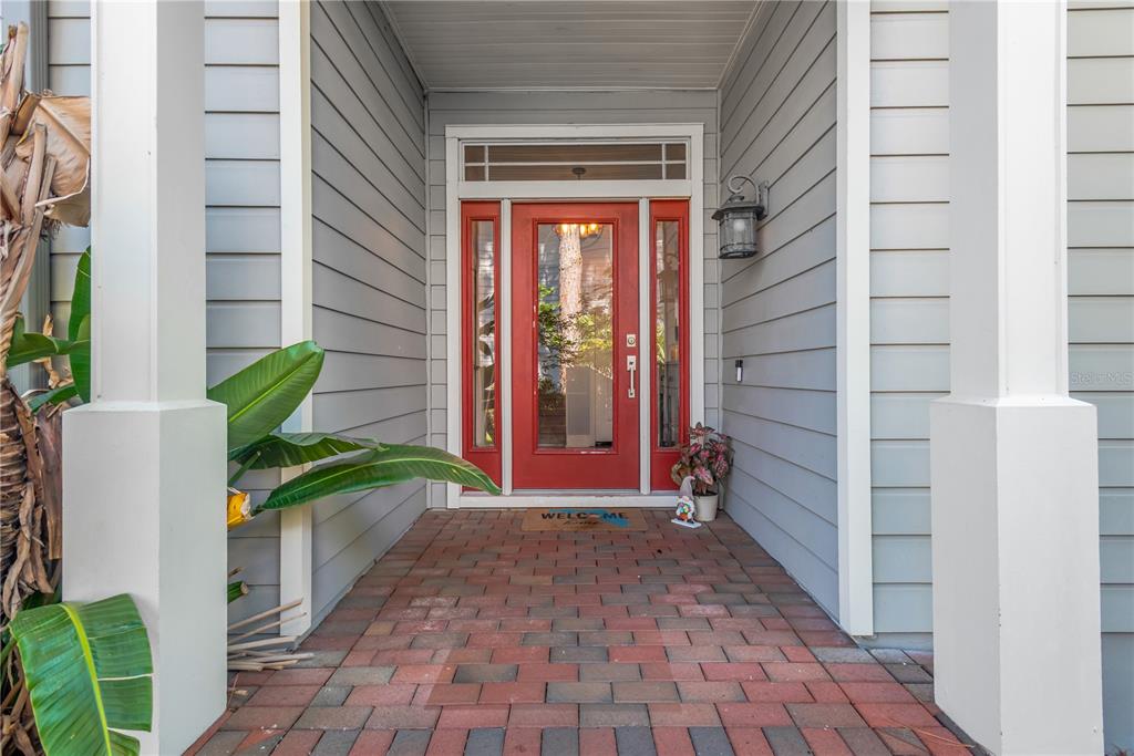 An entryway features a white front door with sidelights, a gray console table, and tile flooring — 2852 BAYSHORE TRAILS DR, TAMPA, FL