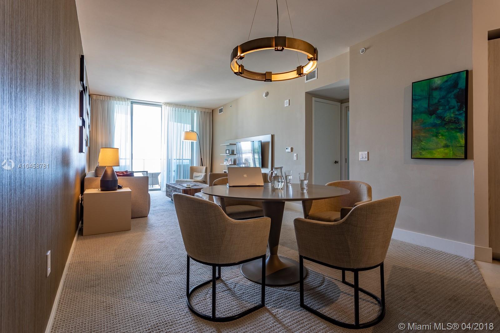 A dining area with a round table and chairs sits in front of a living room — 4111 S ocean dr # 1810, Hollywood FL 33019, HOLLYWOOD, FL
