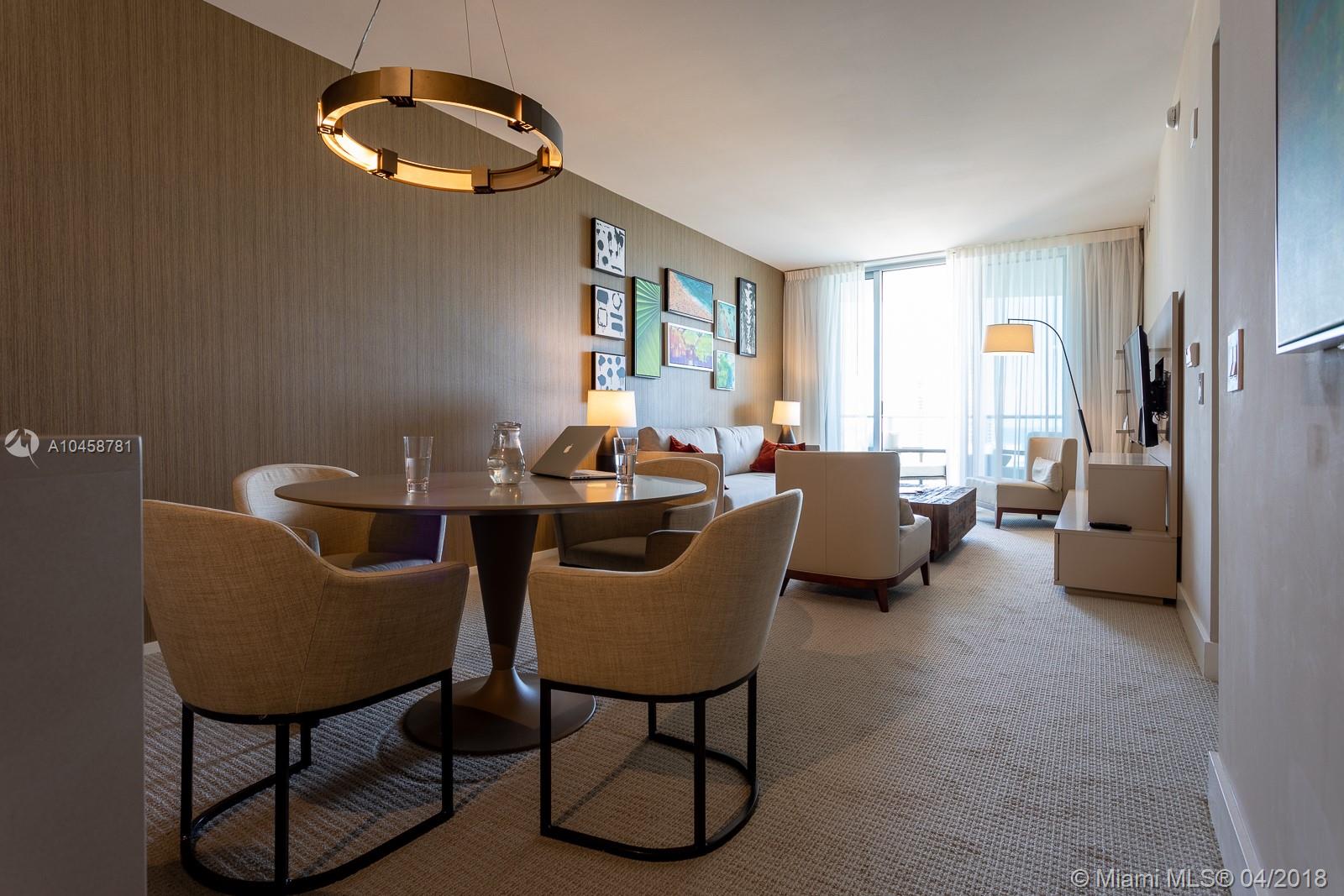 A modern living and dining room with neutral furniture, a circular chandelier, and floor-to-ceiling windows — 4111 S ocean dr # 1810, Hollywood FL 33019, HOLLYWOOD, FL