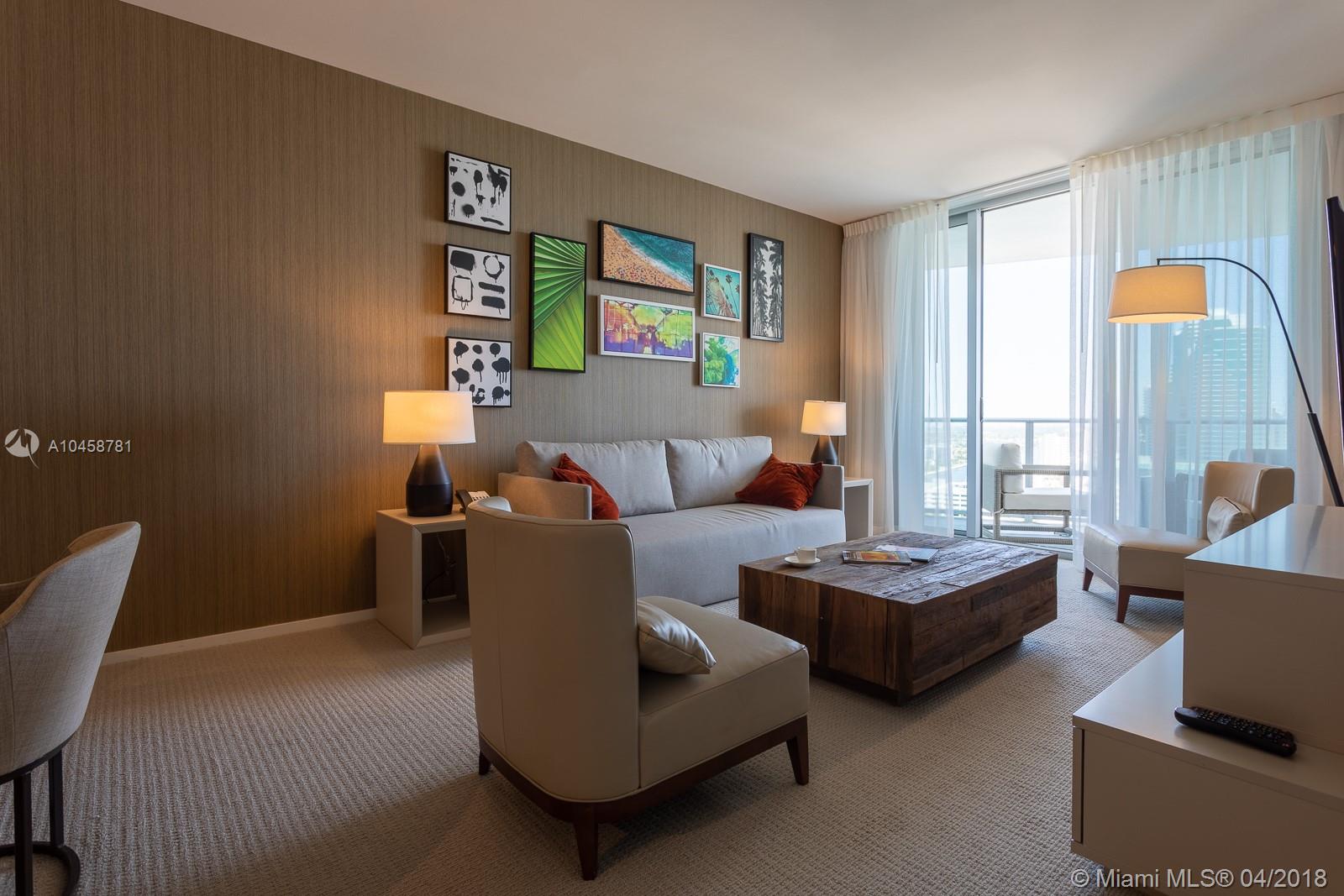 A modern living room features a gray sofa, wooden coffee table, and a gallery wall — 4111 S ocean dr # 1810, Hollywood FL 33019, HOLLYWOOD, FL