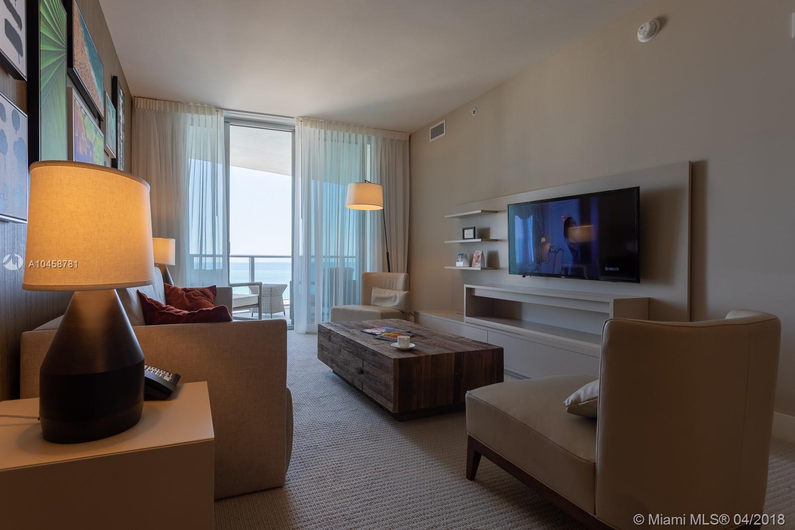 A modern living room features a wooden coffee table, beige seating, and a balcony view — 4111 S ocean dr # 1810, Hollywood FL 33019, HOLLYWOOD, FL