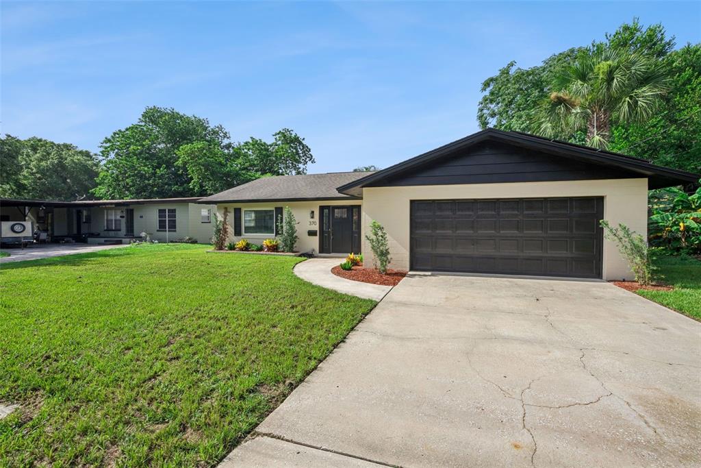 A single-story house with a beige exterior, dark brown trim, and a two-car garage — 370 SULTANA LANE, MAITLAND, FL