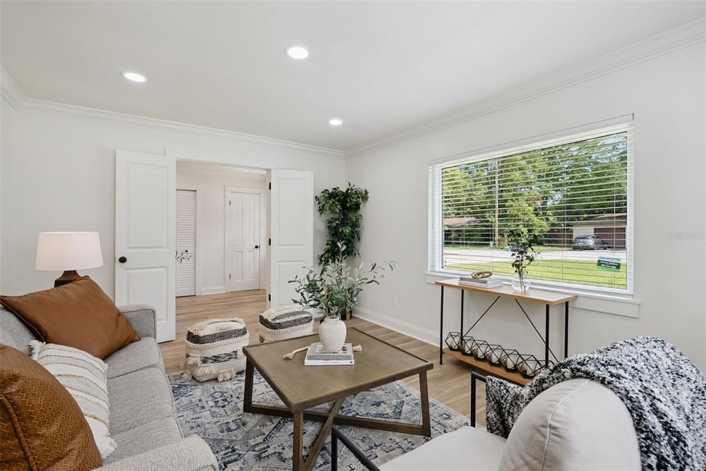 A living room features a grey sofa, a wooden coffee table, and a large window — 370 SULTANA LANE, MAITLAND, FL
