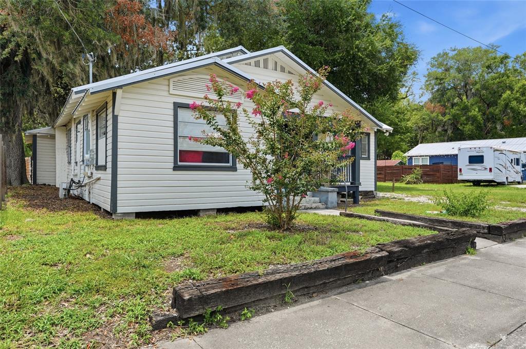 A white, single-story house with a front yard, a small tree, and a parked RV — 619 NW 7TH AVENUE, GAINESVILLE, FL