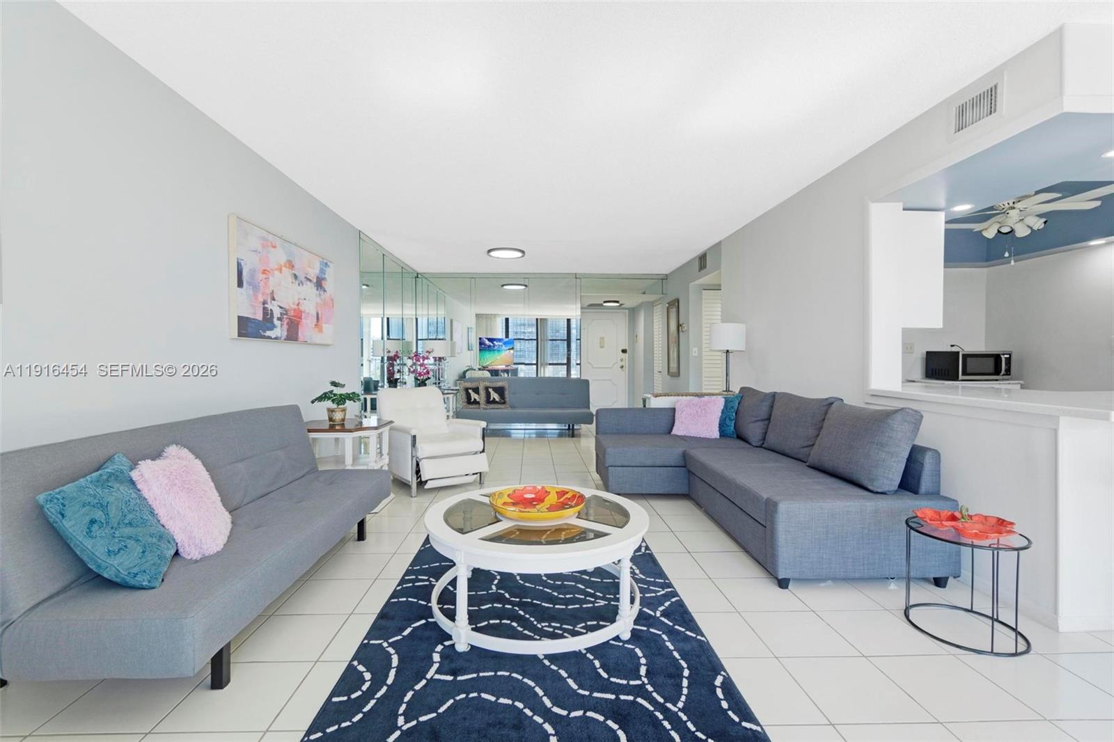 A living room features a sectional sofa, a sofa bed, and a round coffee table — 1000 Parkview Dr # 518, Hallandale Beach FL 33009, HALLANDALE BEACH, FL