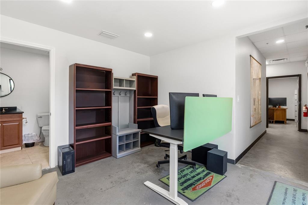 An office space features a standing desk, two bookcases, a coat rack, and an adjacent bathroom — 15617 OLD US HIGHWAY 441, TAVARES, FL