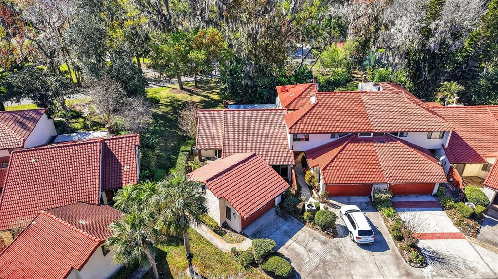 An aerial view shows several attached residential buildings with red tile roofs and driveways — 301 CLUSTERWOOD DRIVE, YALAHA, FL