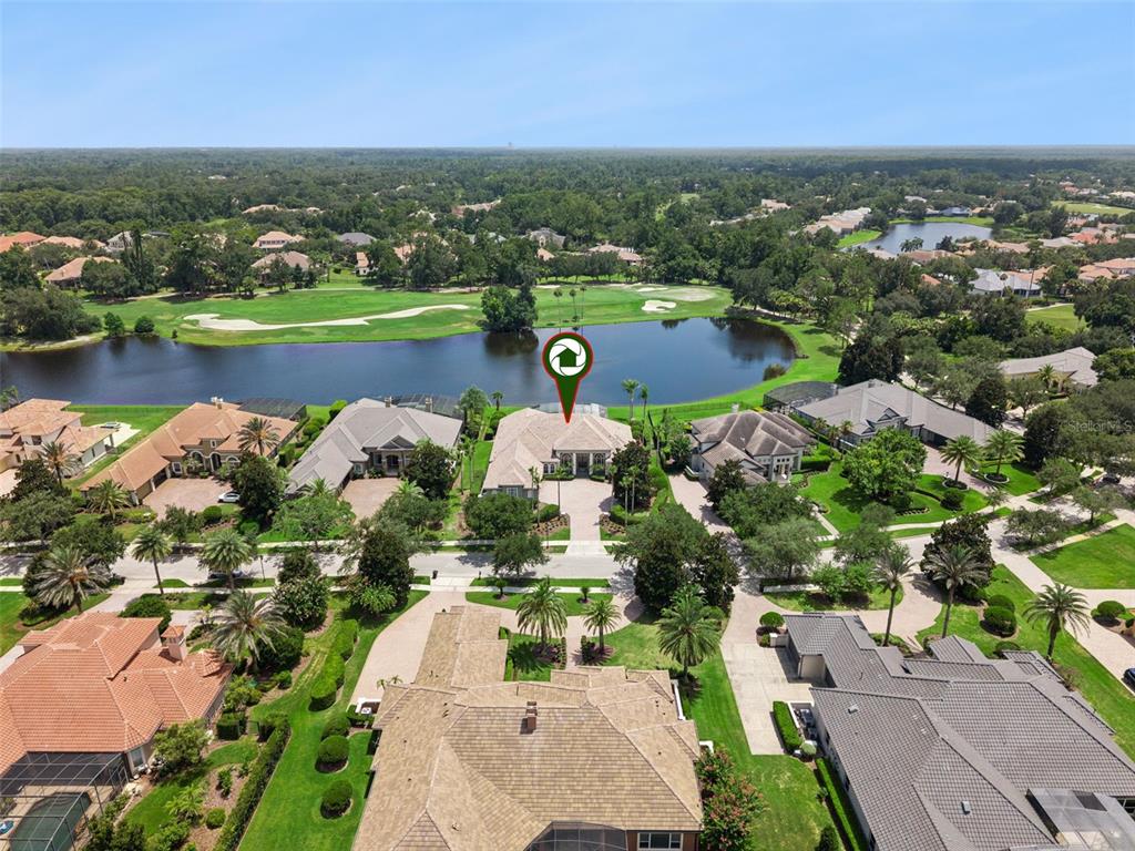 An aerial view shows a residential house with a pool overlooking a lake and golf course — 4013 BERMUDA GROVE PLACE, LONGWOOD, FL