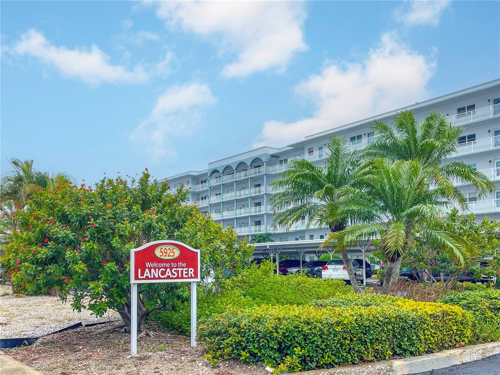 A sign for The Lancaster stands in front of a multi-story apartment building with balconies — 5925 SHORE BOULEVARD S UNIT 405, GULFPORT, FL