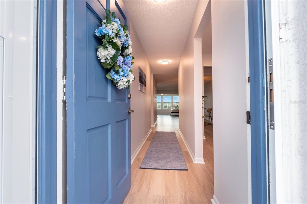 A blue front door with a floral wreath opens to a view of a building — 5925 SHORE BOULEVARD S UNIT 405, GULFPORT, FL