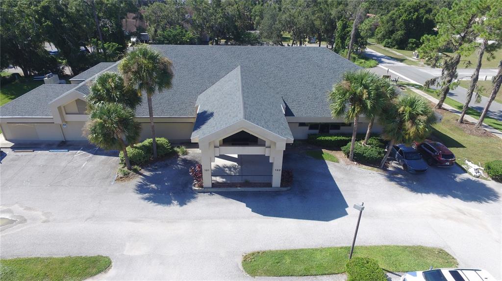 An aerial view of a commercial building with a covered entrance and surrounding parking lot — 640 S LAKE STREET, LEESBURG, FL