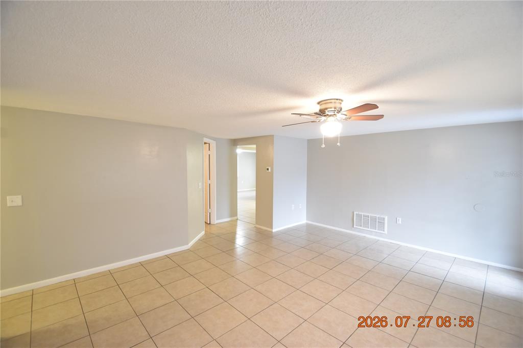 An empty room with light gray walls, tiled flooring, and a ceiling fan — 3221 TOPP DRIVE, HOLIDAY, FL