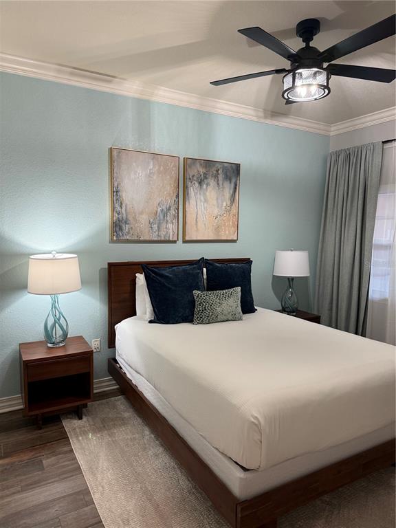 A bedroom features a bed with dark pillows, two nightstands with lamps, and wall art — 7601 CABANA COURT UNIT 103, REUNION, FL
