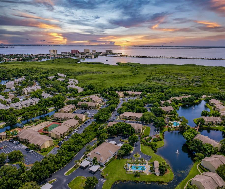 An aerial view of a residential apartment complex near a bay at sunset — 8350 SAVANNAH TRACE CIRCLE UNIT 106, TAMPA, FL