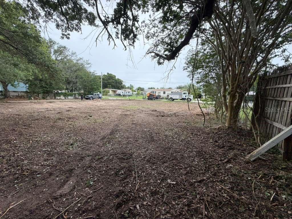A cleared, vacant residential lot features scattered debris, surrounding trees, and a wooden fence — 9640 SE 170TH LANE, SUMMERFIELD, FL