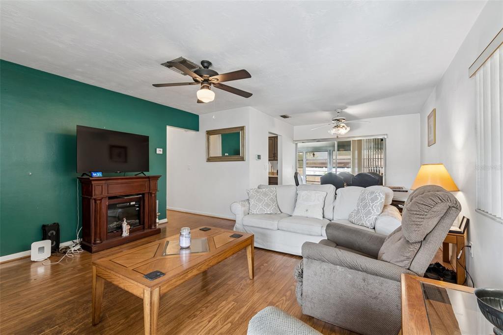 A dining room features a wooden table with leather chairs and a sliding glass door — 6395 TREEHAVEN DRIVE, SPRING HILL, FL
