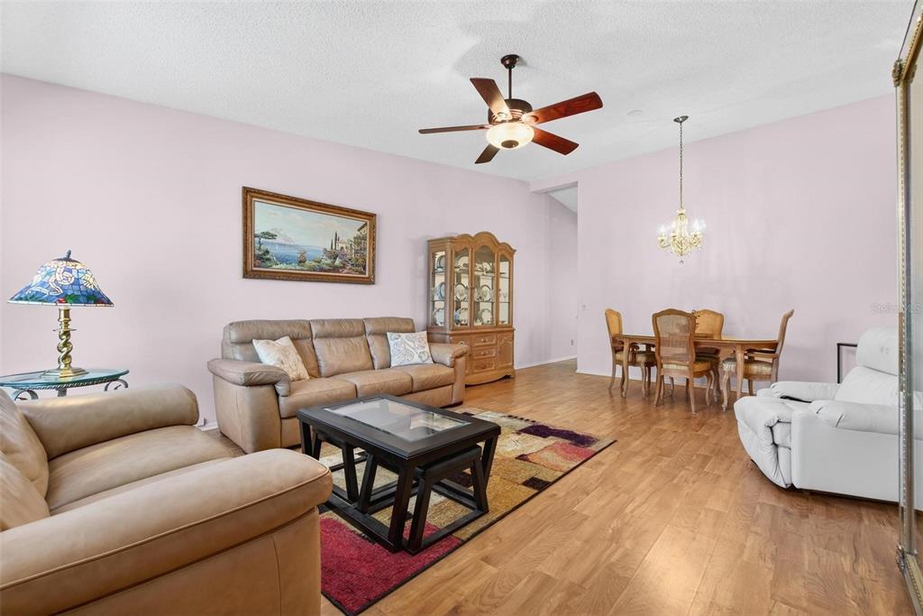 A living and dining room with light pink walls, wood flooring, and a ceiling fan — 2220 SWEDISH DRIVE UNIT 36, CLEARWATER, FL
